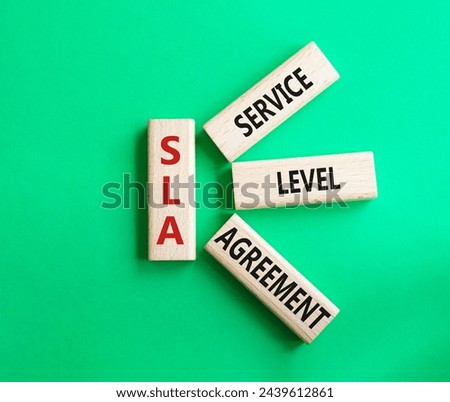 SLA - Service Level Agreement. Wooden blocks with word SLA. Beautiful green background. Business and Service Level Agreement concept. Copy space.