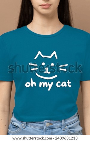Enchanting Sky Blue T-shirt, the epitome of charm and whimsy. Imagine a beautiful girl adorned in this delightful hue, her shirt adorned with the playful "Oh My Cat" typography.  Royalty-Free Stock Photo #2439631213