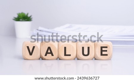 the concept conveyed by the wooden blocks spelling out 'VALUE' suggests a focus on the importance of worth, significance, and importance in business or decision-making contexts.