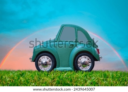 A tiny cartoon style car with a rainbow in the background.  Abstract transportation concept.