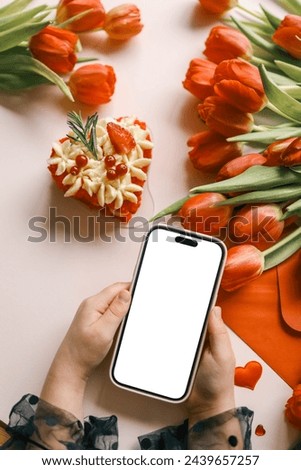 Girl with a phone in her hands with an isolated screen on a background of flowers.