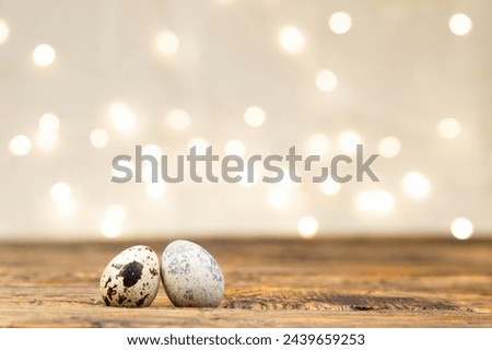 Two eggs on a wooden table, Easter background with blurred lights and highlights. Beautiful shiny easter background with eggs, holiday concept, space for copy, text and advertising