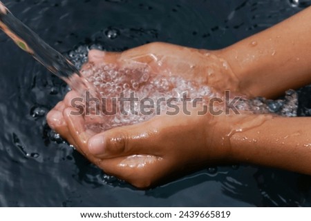 the hand holding the water from the faucet. World water day concept