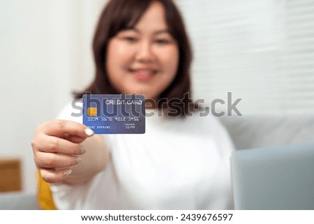 Teenage girl, smiling face, chubby body, shows credit card.