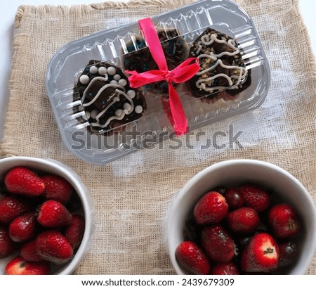 Delicious brigadeiro in square Pet shape on the table with red fruits, Easter food with copy space