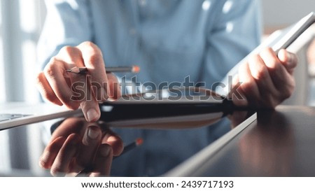 Business woman using digital tablet and planning business event on office table. Student studying online class and taking note on notebook, e-learning, business event planning, close up
