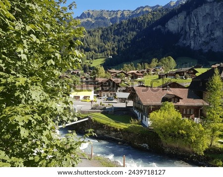 Traditional Swiss chalets and house nestled in the valley at Lauterbrunnen. The valley is surrounded by the famous Eiger, Monch and Jungfrau Swiss Alps Royalty-Free Stock Photo #2439718127