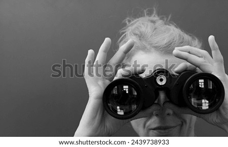 woman looking through binoculars at a sport event with black background with people stock image stock photo	