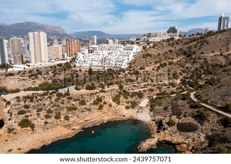 Aerial drone photo or the north part of Benidorm in Spain showing the rocky paths by the ocean in the summer time and the beach known as The Cala Tio Ximo Beach