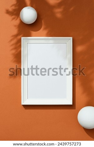 Blank picture frame mockup on brown background with floral shadows