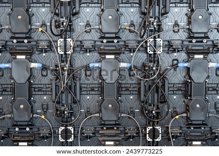 Backside of big LED screen monitor display. Texture of back view panels. Power input and output wire and data input and output plug. Digital electronic screen Royalty-Free Stock Photo #2439773225