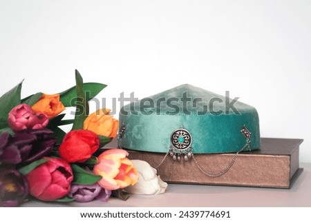 Kazakh national hat takiya or tubeteika - traditional Kazakh headwear. Modern qazaq hat. Traditional Kazakh headwear isolated on white background with tulips. Royalty-Free Stock Photo #2439774691