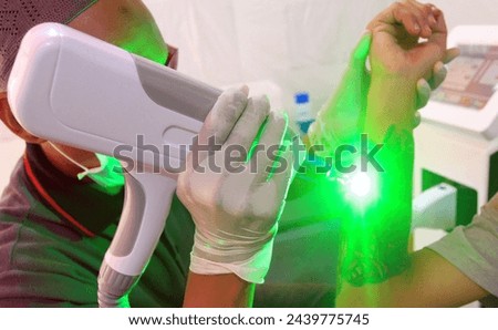 Jakarta, April 27 2018, Officers carry out free laser tattoo removal while waiting for fast breaking hours during the month of Ramadan in Central Jakarta. Royalty-Free Stock Photo #2439775745