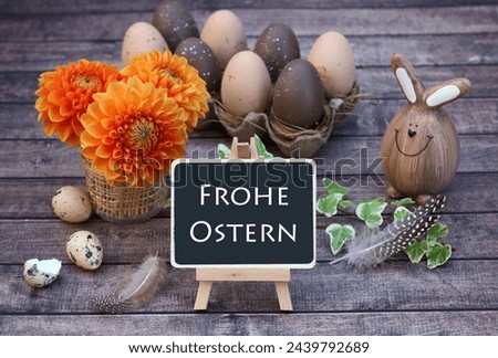 Bouquet of flowers with Easter eggs on shabby wooden board with the text Happy Easter. German inscription translates as Happy Easter.