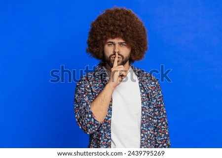 Shh be quiet please. Caucasian man presses index finger to lips makes silence gesture sign do not tells secret, stop talk gossip, confidential privacy. Stylish guy on blue background. Copy-space