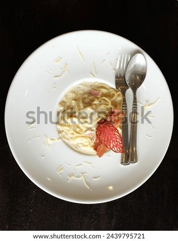 Picture of delicious
Spaghetti Carbonara with Bacon Ham Parsley 
and mushroom cream sauce with ham 
Ready to serve on a white ceramic plate.
Traditional Italian food, top view