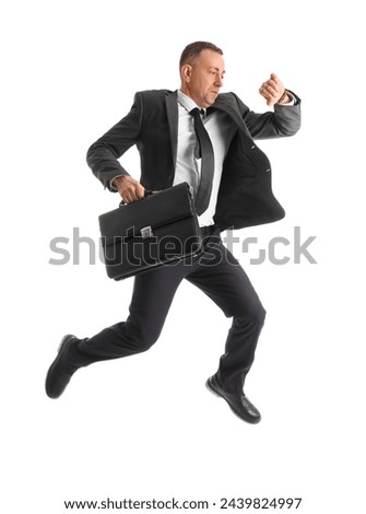 Hurrying businessman with briefcase checking time while jumping on white background Royalty-Free Stock Photo #2439824997