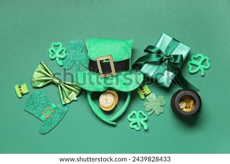 Leprechaun hat with gift box, bow tie and decor on green background. St. Patrick's Day celebration