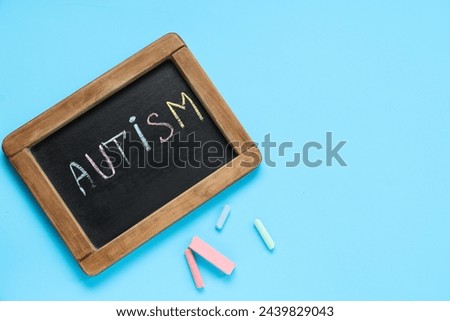 Blackboard with word AUTISM on blue background. Autism disorder concept