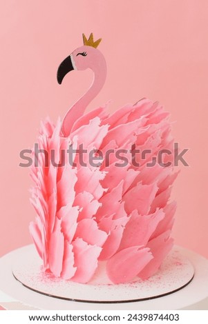 Cute pink cake with flamingo on paper pink and balloons background in studio