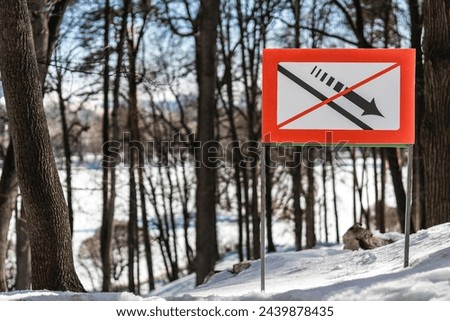 a sign prohibiting descent from the slope stands on a hill in the forest. prohibition of descent from the slope Royalty-Free Stock Photo #2439878435
