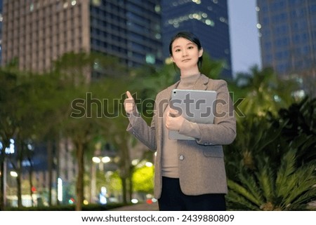 Confident Businesswoman With Thumbs Up In City