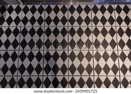 Black and white diamond pattern tiles hit by spotlight
