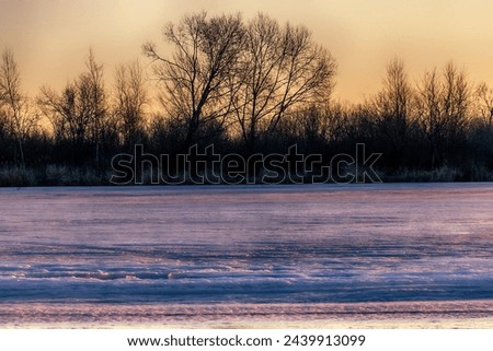 North-eastern European river after frosty winter. Porous ice began to melt, river is swollen, state of ice week before ice break (ice-boom). Aurora, sunrise colors on a spring moning Royalty-Free Stock Photo #2439913099