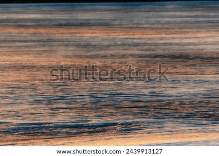 North-eastern European river after frosty winter. Ice began to melt, ice is saturated with meltwater. The morning sun colors ice surface, sunny path, iridescent reflection of sun on surface of ice Royalty-Free Stock Photo #2439913127