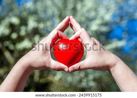 Girl holding a heart on a background of appletree blossoms
