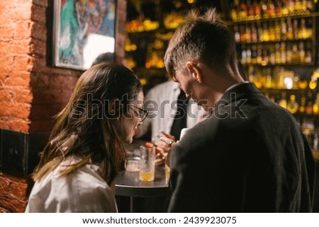 Man invites pretty woman to apartment and orders car after party at night club. End of evening with music and subdued lighting in bar