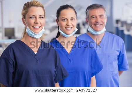 Portrait of smiling co-workers standing in a line in dental clinic Royalty-Free Stock Photo #243992527