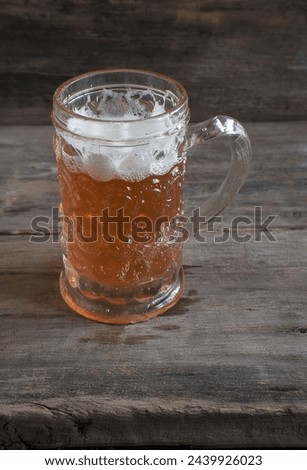 Vintage mug of light beer on a old wooden background; vertical picture