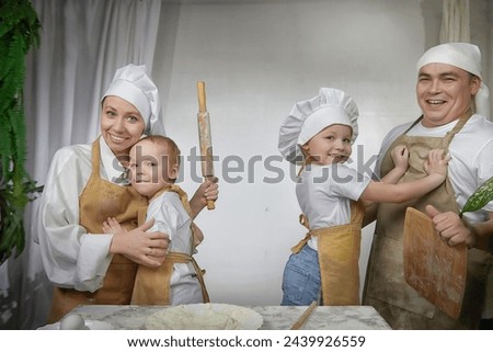 Cute oriental family with mother, father, daughter, son cooking in the kitchen on Ramadan, Kurban-Bairam, Eid al-Adha. Funny family at cook photo shoot. Pancakes, pastries, Maslenitsa, Easter