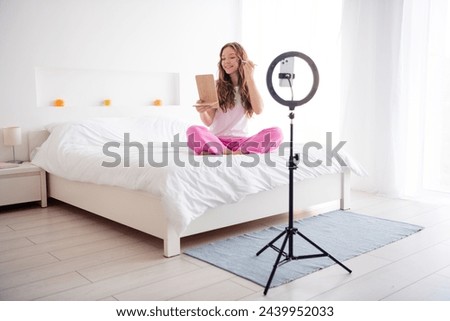 Full size photo of pretty girl sit bed hold mirror apply tone cream record blog smart phone lamp holder bedroom indoors
