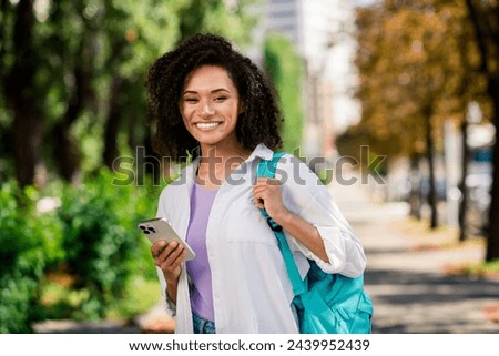 Photo of pretty sweet woman dressed white shirt backpack typing instagram twitter telegram facebook outdoors urban city park