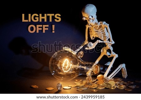 A toy cheerful human skeleton is kneeling by a large dimly lit light bulb, holding the last pennies for expensive electricity. Text in the photo - Lights off.