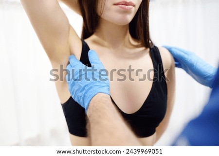 Doctor mammalogist examines woman breasts and lymph nodes. Correcting the shape of the breast - lift, reduction, reconstruction, augmentation. Problems of lactation. Breast cancer awareness Royalty-Free Stock Photo #2439969051
