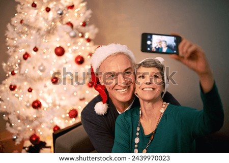 Christmas, selfie and senior couple with love, holiday and support in home with social media. Happy, retirement and marriage with smile and profile picture in house with celebration and santa hat