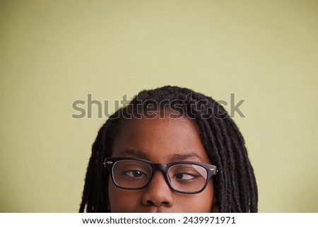 Glasses, vision and boy kid with cross eyes in studio for eye care, testing or optometry on green background. Medical, help and black teen model with eyeball correcting lens, prescription or solution
