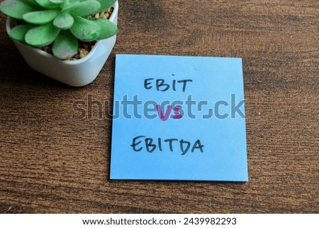 Concept of Ebit vs Ebitda write on sticky notes isolated on Wooden Table.