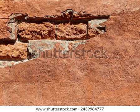 Red brick wall of an old building with crumbling plaster. Copy space. Selective focus. Royalty-Free Stock Photo #2439984777