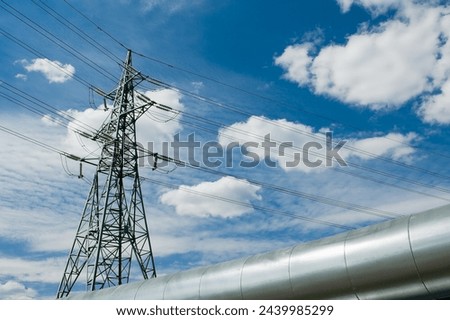pipeline and power lines against a blue sky.