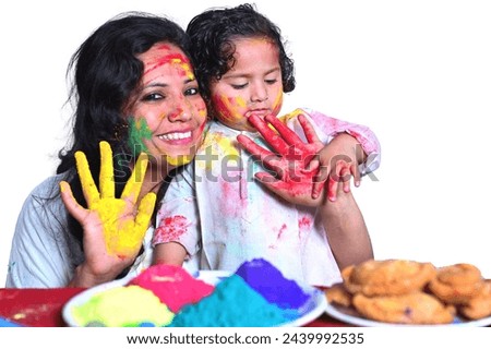Mother and daughter celebrate the festival Holi with colours.