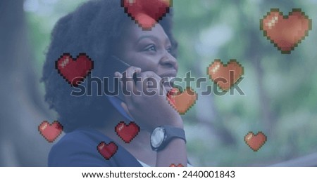 Image of heart icons over african american woman talking on smartphone. Global social media, technology and digital interface concept digitally generated image.