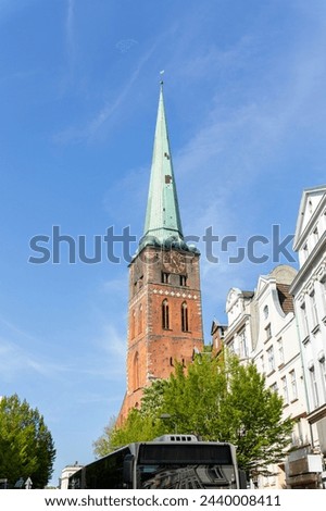 Close-up view of spire steeple of St Jakobi gothic church with clocks in old Lubeck town center. UNESCO heritage city altstatd in Germany travel destination Royalty-Free Stock Photo #2440008411