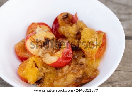 Wormy apricots on plates. Rotten apricots Royalty-Free Stock Photo #2440011599