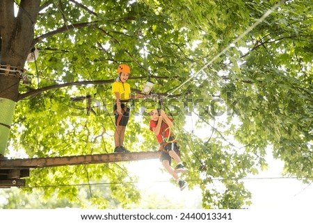 Happy child climbing in the trees. Rope park. Climber child. Early childhood development. Roping park. Balance beam and rope bridges. Rope park - climbing center Royalty-Free Stock Photo #2440013341