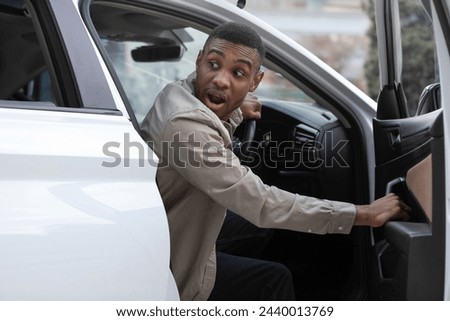 The man opened the door of his car looks back frightened