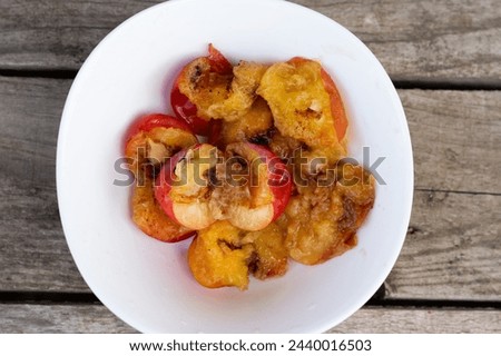 Wormy apricots on plates. Rotten apricots Royalty-Free Stock Photo #2440016503